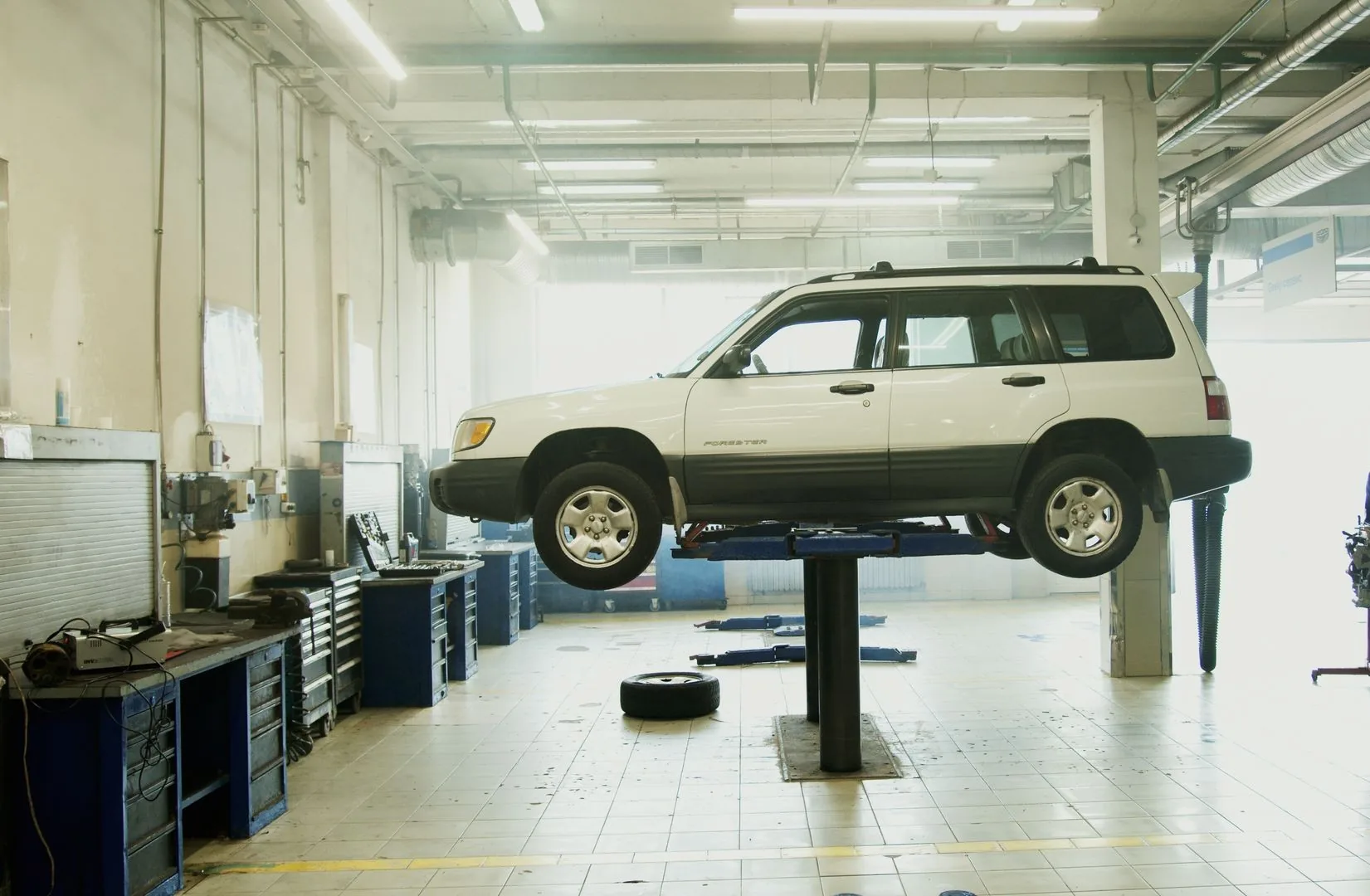 Vehicle raised on a lift inside a clean, well-lit repair workshop
